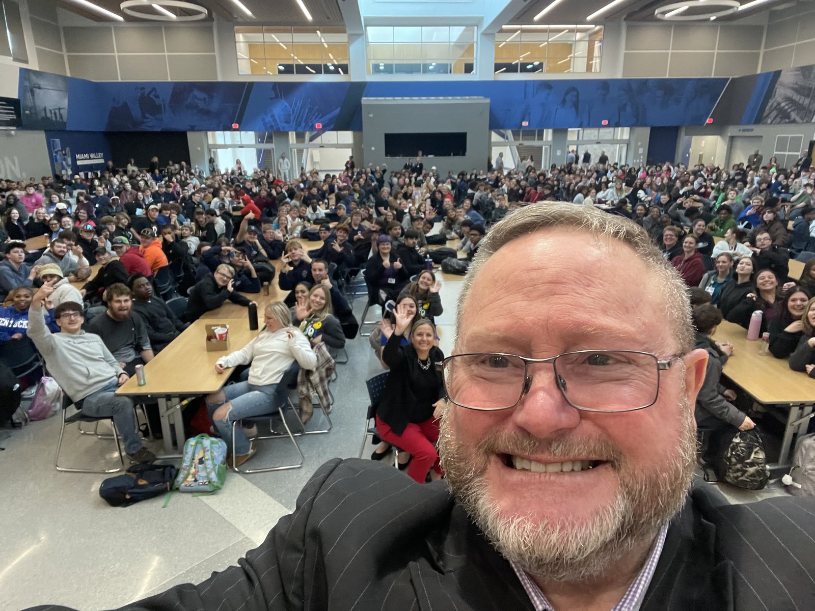 Eric Combs speaking to a packed student assembly
